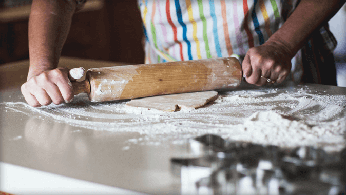 TV screen showing video of a person rolling dough with a rolling pin, and showing that the same video is being cast from a laptop.